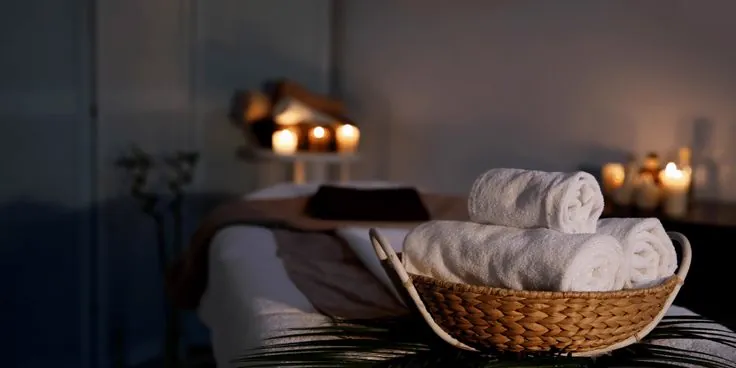 Rolled towels in candlelit spa room at Meditative Spa