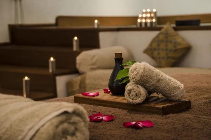 Spa treatment room decorated with rose petals and candles